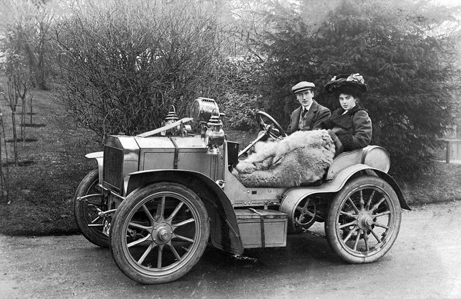 Black and white early twentieth-century image of a couple in a vehicle.