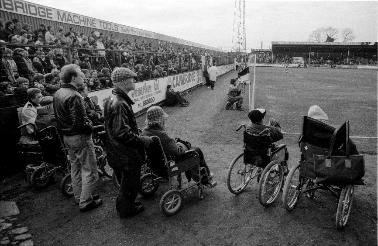 Supporters in wheelchairs watching a match at the Abbey Stadium, home of Cambridge United Football Club. 18 January 1992.